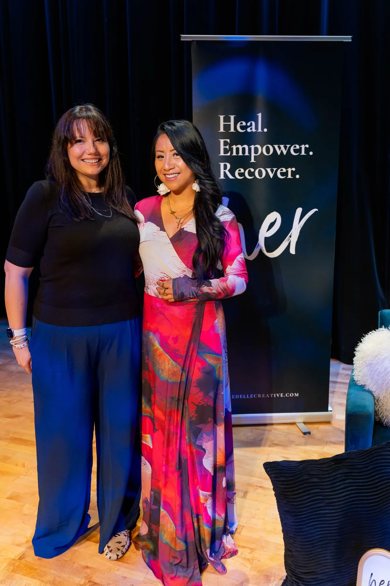 Brooke and a guest in front of the HER. banner